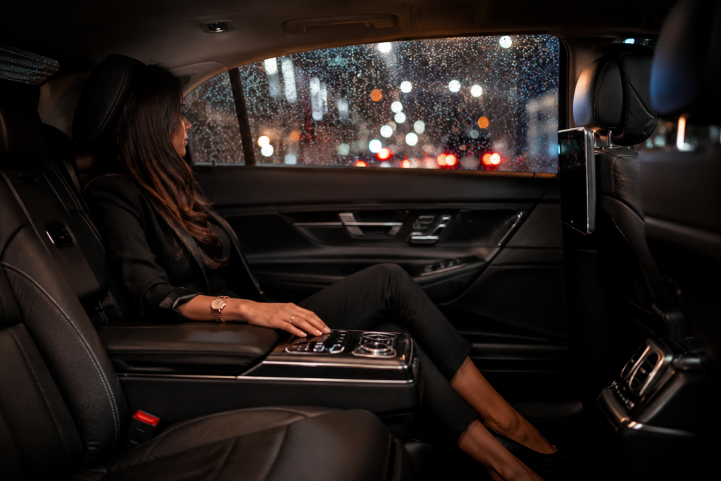 Passageiro relaxado no banco traseiro espaçoso de um carro premium em dia de chuva.