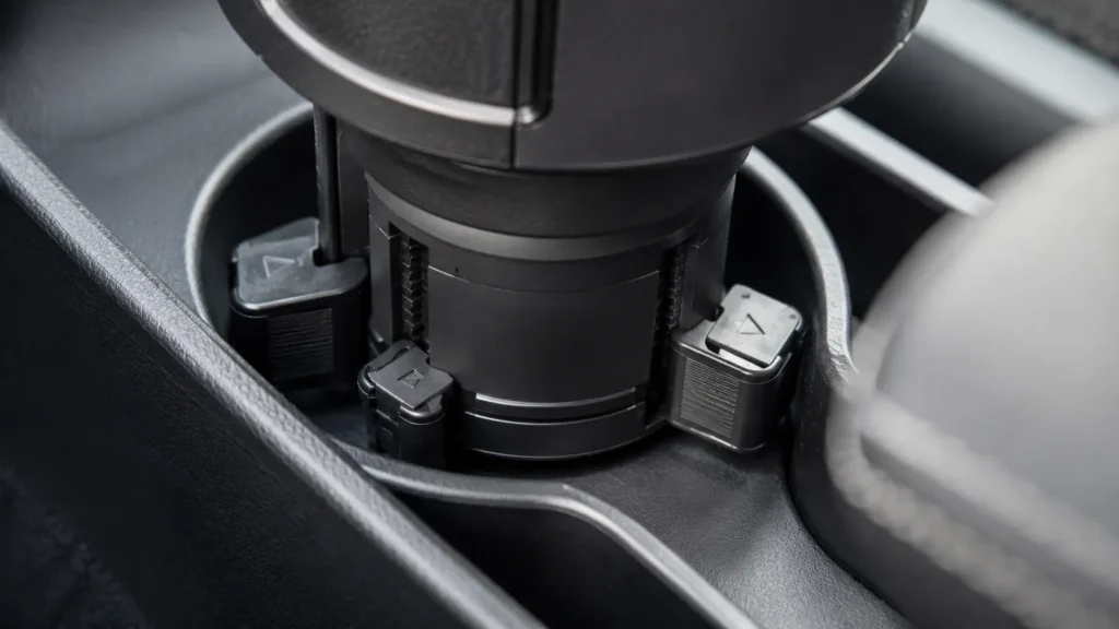 Detalhe da base ajustável expansível do porta-copo para carro mostrando fixação firme e proteção antirrisco.